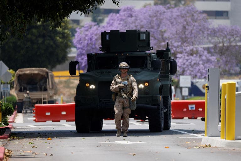 Fact Check: A U.S Marine holds a rifle outside of a federal building, Friday, June 13, 2025, in Los Angeles.